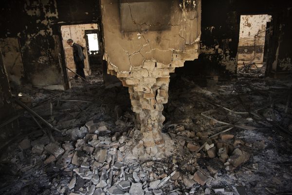 A man wearing a surgical mask walks, 14 October 2015, amongst the debris of the damaged and burnt-out MSF Trauma Centre in Kunduz, northern Afghanistan - Sputnik International