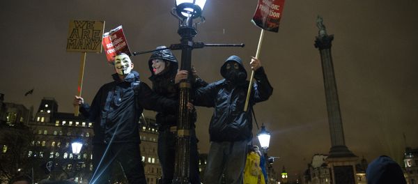 Anti-capitalist protesters wearing Guy Fawkes masks hold placards as they gather at Trafalgar Square ahead of the Million Masks March, organised by the group Anonymous, in London on November 5, 2015. Anti-capitalist protesters wearing Guy Fawkes masks hold placards as they gather at Trafalgar Square ahead of the Million Masks March, organised by the group Anonymous, in London on November 5, 2015. - Sputnik International