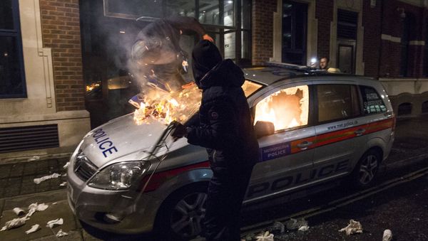 Anti-capitalist protesters attack a British police car during the Million Masks March, organised by the group Anonymous, near the Houses of Parliament in London on November 5, 2015. - Sputnik International