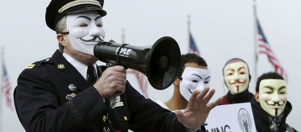 Captain Lewis, a retired Philadelphia police officer, protests with members of the Anonymous Army, with their signature Guy Fawkes masks, in front of the Washington Monument in Washington, November 5, 2015.Captain Lewis, a retired Philadelphia police officer, protests with members of the Anonymous Army, with their signature Guy Fawkes masks, in front of the Washington Monument in Washington, November 5, 2015. - Sputnik International
