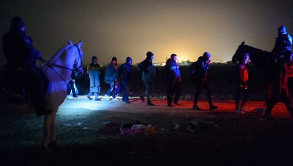 Migrants and refugees queue to board buses to go to a refugee center after crossing Croatian-Slovenian border in Rigonce on October 27, 2015 Migrants and refugees queue to board buses to go to a refugee center after crossing Croatian-Slovenian border in Rigonce on October 27, 2015 - Sputnik International
