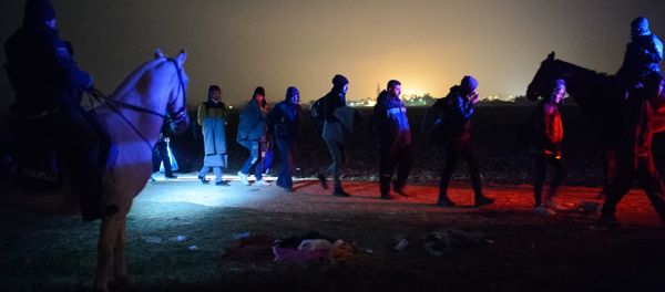 Migrants and refugees queue to board buses to go to a refugee center after crossing Croatian-Slovenian border in Rigonce on October 27, 2015 - Sputnik International
