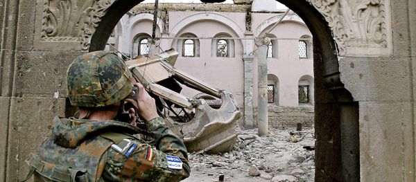 A German KFOR soldier takes photographs of the destroyed St. George Orthodox church in Prizren 22 March 2004 A German KFOR soldier takes photographs of the destroyed St. George Orthodox church in Prizren 22 March 2004 - Sputnik International