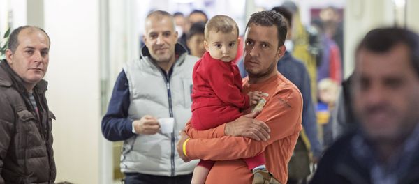 People wait in the initial reception center for asylum seekers in Halle/Saale, Germany, Friday, Oct. 16, 2015 People wait in the initial reception center for asylum seekers in Halle/Saale, Germany, Friday, Oct. 16, 2015 - Sputnik International