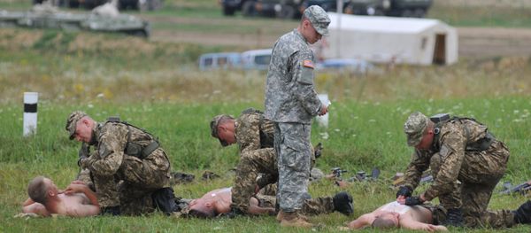 US serviceman teaches Ukrainian soldiers how to give emergency medical aid during the Rapid Trident/Saber Guardian 2015 military exercises at the International Peacekeeping and Security Centre base outside Lviv, Ukraine, Friday, July 24, 2015 - Sputnik International