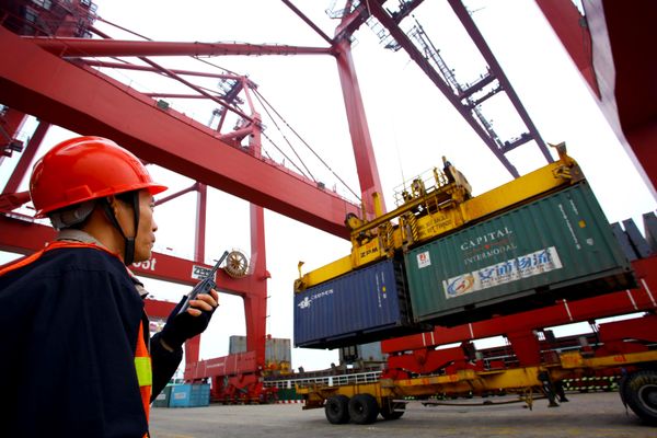 This photo taken on January 8, 2012 shows a worker operating hoists to unload containers at the Kaikou port, in south China's Hainan province - Sputnik International