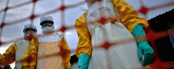(FILES) A file picture taken on August 14, 2014 shows Medecins Sans Frontieres (MSF) medical staff wearing protective clothing treating the body of an Ebola victim at their facility in Kailahun - Sputnik International