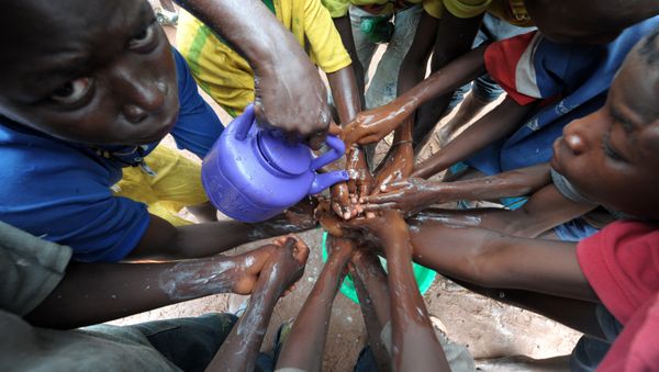 (FILES) A file picture taken on September 3, 2014 shows people washing their hands with soap and bleach to prevent the spread of the Ebola virus - Sputnik International
