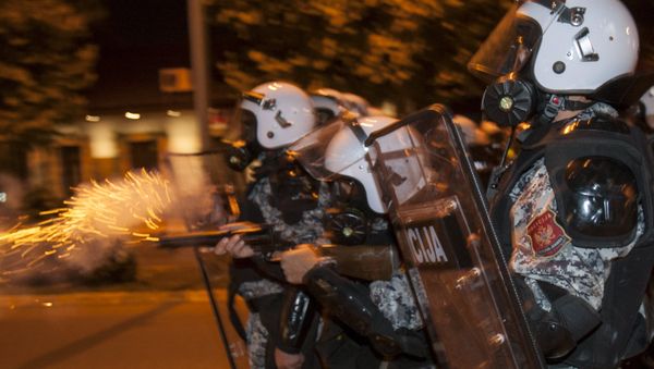 A riot policeman fires tear gas at protesters in front of the parliament building in Podgorica, Montenegro, October 24, 2015 - Sputnik International