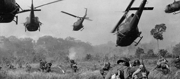 Hovering U.S. Army helicopters pour machine gun fire into the tree line to cover the advance of South Vietnamese ground troops in an attack on a Viet Cong camp 18 miles north of Tay Ninh, northwest of Saigon near the Cambodian border, in March 1965 during the Vietnam War - Sputnik International