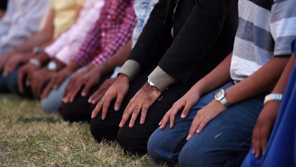 Muslim men kneel to pray in front of MacArthur High School at a prayer vigil in support of Ahmed Mohamed, Thursday, Sept. 17, 2015, in Irving, Texas - Sputnik International