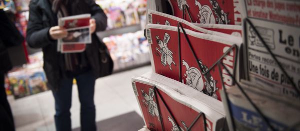 A man holds the latest edition of French satirical weekly newspaper Charlie Hebdo at a train station in Paris. File photo - Sputnik International