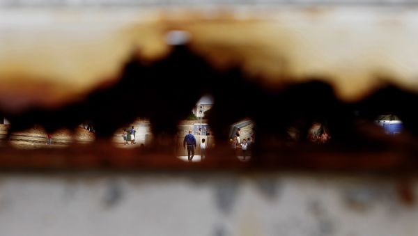 Migrants walk are seen through a hole of the rusty main gate at the temporary transit facility in Dhekelia Garrison, a British military base on the east Mediterranean island of Cyprus on Wednesday, Oct. 28, 2015. Migrants walk are seen through a hole of the rusty main gate at the temporary transit facility in Dhekelia Garrison, a British military base on the east Mediterranean island of Cyprus on Wednesday, Oct. 28, 2015. - Sputnik International