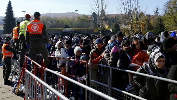 Austrian army soldiers observe migrants as they wait to cross the border from the village of Sentilj, Slovenia into Spielfeld in Austria, November 2, 2015 - Sputnik International