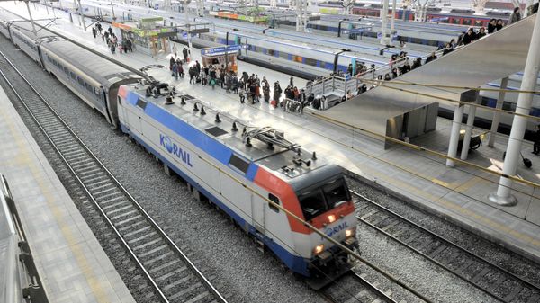 Mugunghwa train (front) is seen as passengers get off a train of the Korea Train eXpress (KTX), South Korea's high-speed rail system based on the French TGV/LGV system. - Sputnik International
