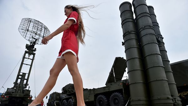 A woman walks near Russia's air defence system S-400 Triumf launch vehicles at the military exhibition A woman walks near Russia's air defence system S-400 Triumf launch vehicles at the military exhibition - Sputnik International