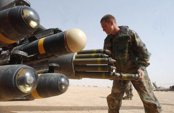 US Army armament crew specialist Michael Mayo, from Florida, loads the rocket pod of an an Apache AH-64D attack helicopter also armed with Hellfire missiles at left - Sputnik International
