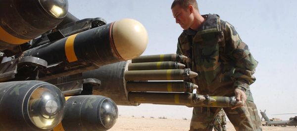 US Army armament crew specialist Michael Mayo, from Florida, loads the rocket pod of an an Apache AH-64D attack helicopter also armed with Hellfire missiles at left - Sputnik International