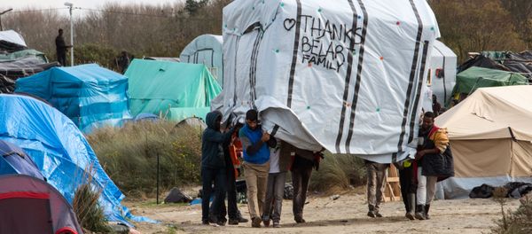 Migrant men move a tent in the New Jungle migrant camp in Calais on November 12, 2015. - Sputnik International