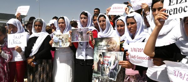 Yazidi Kurdish women hold posters during a protest against the Islamic State group's invasion on Sinjar city one year ago, in Dohuk, northern Iraq. - Sputnik International