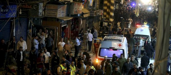 Red Cross vehicles drive by as residents and Lebanese army members inspect a damaged area caused by two explosions in Beirut's southern suburbs, Lebanon November 12, 2015 - Sputnik International