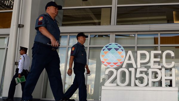 Philippine policemen walk past an Asia Pacific Economic Cooperation (APEC) summit logo in front of the media centre in Manila Philippine policemen walk past an Asia Pacific Economic Cooperation (APEC) summit logo in front of the media centre in Manila - Sputnik International