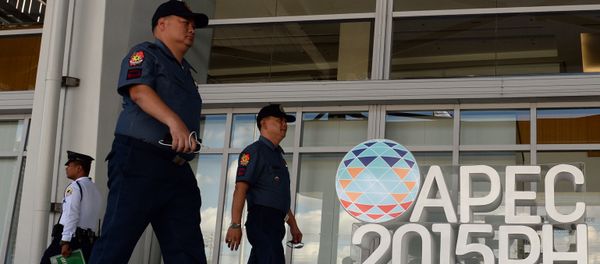 Philippine policemen walk past an Asia Pacific Economic Cooperation (APEC) summit logo in front of the media centre in Manila Philippine policemen walk past an Asia Pacific Economic Cooperation (APEC) summit logo in front of the media centre in Manila - Sputnik International