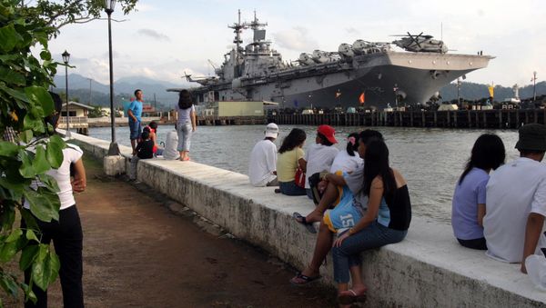 People stand near the docked amphibious assault ship USS Essex at Subic Bay, Philippines. People stand near the docked amphibious assault ship USS Essex at Subic Bay, Philippines. - Sputnik International
