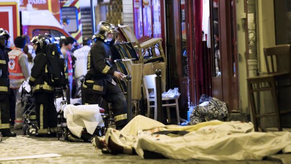 A rescue worker walks plast a victim in the 10th district of Paris, Friday, Nov. 13, 2015. - Sputnik International