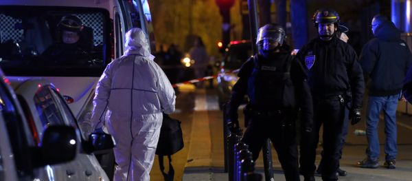An investigating police officer, left, arrives outside the Stade de France stadium after an international friendly soccer match France against Germany, in Saint Denis, outside Paris, Friday Nov. 13, 2015. - Sputnik International