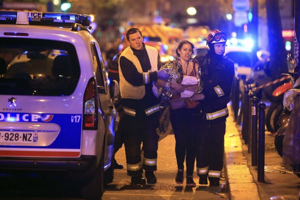 Rescue workers help a woman after a shooting, outside the Bataclan theater in Paris, Friday Nov. 13, 2015.  - Sputnik International