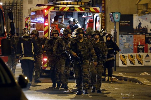 Soldiers walk in front of an ambulance as rescue workers evacuate victims near La Belle Equipe, rue de Charonne, at the site of an attack on Paris on November 14, 2015  - Sputnik International