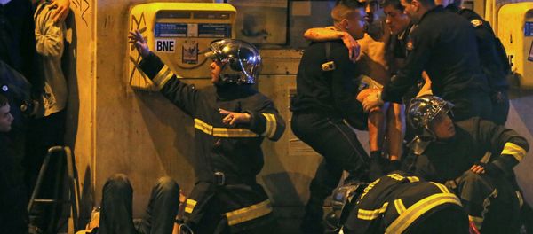 French fire brigade members aid an injured individual near the Bataclan concert hall following fatal shootings in Paris, France, November 13, 2015 - Sputnik International