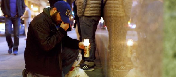 A man gestures as he places a candle at a makeshift memorial outside the Consulate General of France to pay tribute to the victims of the terror attack in Paris, in San Francisco, California November 13, 2015 - Sputnik International