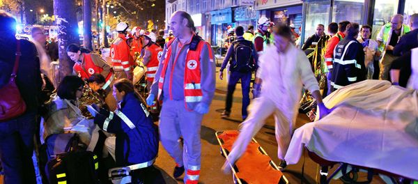 People rest on a bench after being evacuated from the Bataclan theater after a shooting in Paris, Saturday, Nov. 14, 2015 - Sputnik International