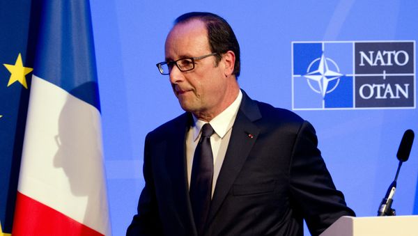 A shadow of France's President Francois Hollande is cast on a flag as he leaves a press conference on the second day of the NATO 2014 Summit at the Celtic Manor Resort in Newport, South Wales, on September 5, 2014 - Sputnik International