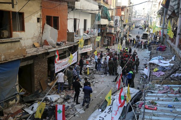 Lebanese army soldiers and security forces gather as Lebanese and Hezbollah flags are erected at the site of the two explosions that occured on Thursday in the southern suburbs of the Lebanese capital Beirut, November 13, 2015 - Sputnik International