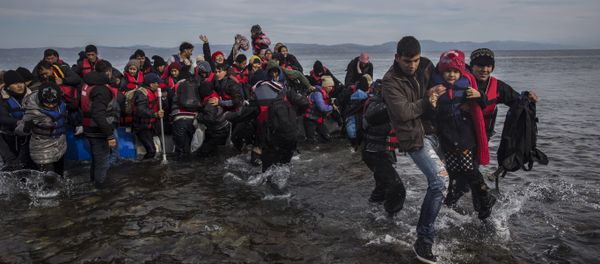 Migrants and refugees disembark safely from a dinghy at a beach on the Greek island of Lesbos after crossing the Aegean sea from the Turkish coast, Monday, Nov. 16, 2015 Migrants and refugees disembark safely from a dinghy at a beach on the Greek island of Lesbos after crossing the Aegean sea from the Turkish coast, Monday, Nov. 16, 2015 - Sputnik International