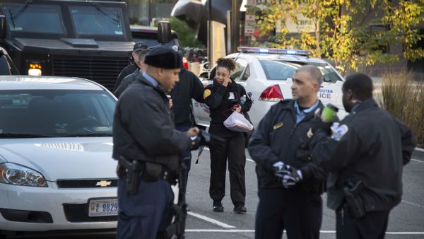 A security guard (C) is escorted out of a building on 19th and K Street NW in Washington, DC, November 16, 2015, by DC Metropolitan Police during a barricade situation - Sputnik International