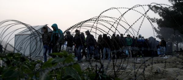 People cross the border from Greece into Macedonia, near the southern Macedonian town of Gevgelija, early Saturday, Nov. 14, 2015 People cross the border from Greece into Macedonia, near the southern Macedonian town of Gevgelija, early Saturday, Nov. 14, 2015 - Sputnik International