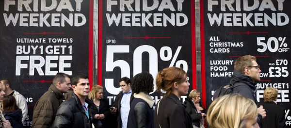 Shoppers are pictured walking past 'Black Friday' advertising in shop windows on Oxford Street in central London on November 28, 2014. - Sputnik International