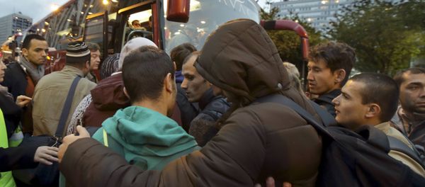 Migrants board buses after their evacuation from the Lycee Jean Quarre, an empty secondary school occupied by hundred of migrants and asylum seekers in the 19th district in Paris, France, October 23, 2015. - Sputnik International