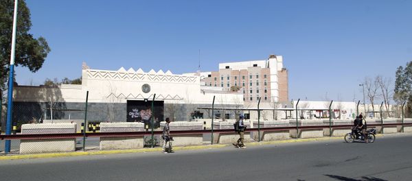 Yemenis walk past the compound of the US embassy in the Yemeni capital Sanaa - Sputnik International