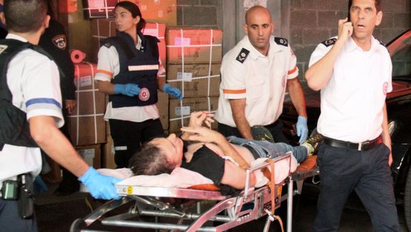 A wounded Israeli man is evacuated following a stabbing attack in Tel Aviv - Sputnik International