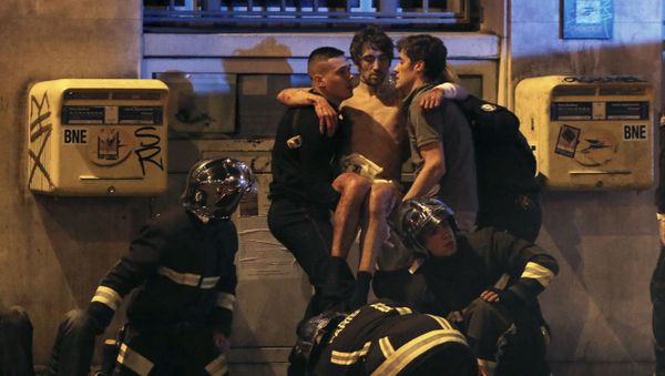 French fire brigade members aid an injured individual near the Bataclan concert hall following fatal shootings in Paris, France, November 13, 2015. - Sputnik International