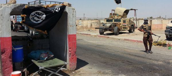 An ISIL militant stands with a captured Iraqi Army Humvee at a checkpoint outside Beiji refinery, some 250 kilometers (155 miles) north of Baghdad, Iraq, Thursday, June 19, 2014 - Sputnik International
