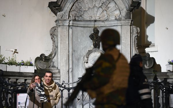 A soldier patrols around a security perimeter next to tourists taking a photo of the Manneken Pis statue, as a reported police intervention takes place, in Brussels on November 22, 2015. A soldier patrols around a security perimeter next to tourists taking a photo of the Manneken Pis statue, as a reported police intervention takes place, in Brussels on November 22, 2015. - Sputnik International