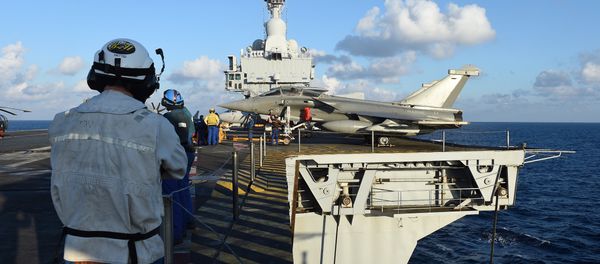 French navy technicians work near a French Rafale aircraft on the flight deck on the aircraft carrier Charles-de-Gaulle, in eastern Mediterranean sea, on November 21, 2015 - Sputnik International