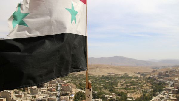 In this photo taken on Sunday, Oct. 18, 2015, a Syrian flag flies above the village of Maaloula, north of Damascus, Syria In this photo taken on Sunday, Oct. 18, 2015, a Syrian flag flies above the village of Maaloula, north of Damascus, Syria - Sputnik International