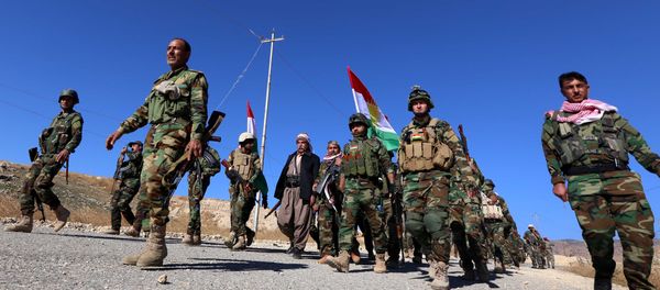 Iraqi autonomous Kurdish region's peshmerga forces and fighters from the Yazidi minority, a local Kurdish-speaking community which the Islamic State (IS) group had brutally targeted in the area, enter the northern Iraqi town of Sinjar, in the Nineveh Province, on November 13, 2015 Iraqi autonomous Kurdish region's peshmerga forces and fighters from the Yazidi minority, a local Kurdish-speaking community which the Islamic State (IS) group had brutally targeted in the area, enter the northern Iraqi town of Sinjar, in the Nineveh Province, on November 13, 2015 - Sputnik International